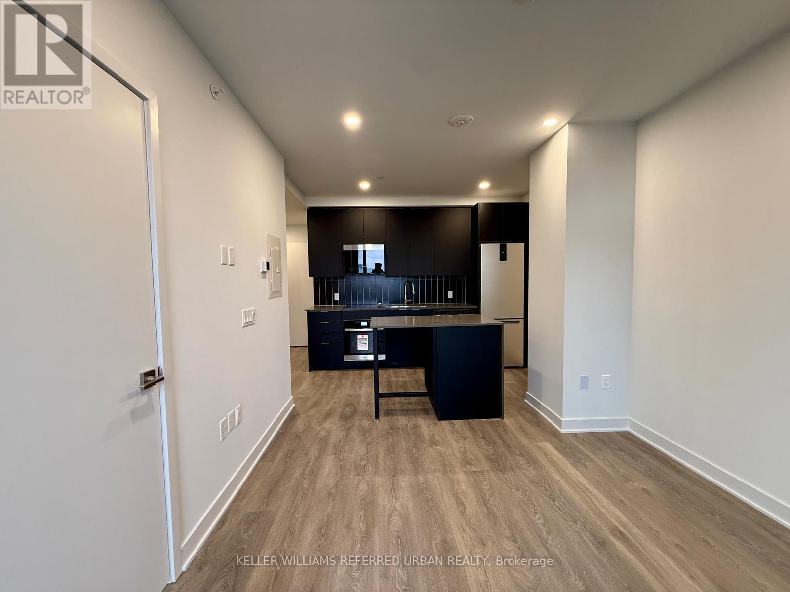 A spacious room with a kitchenette and bar area.