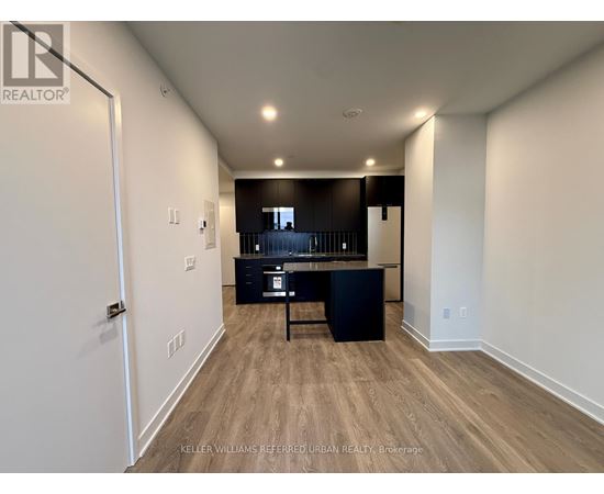 A spacious room with a kitchenette and bar area.