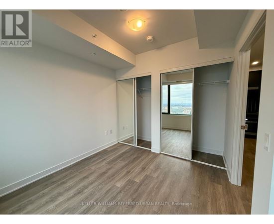 A spacious room with a sliding glass door leading to a balcony.