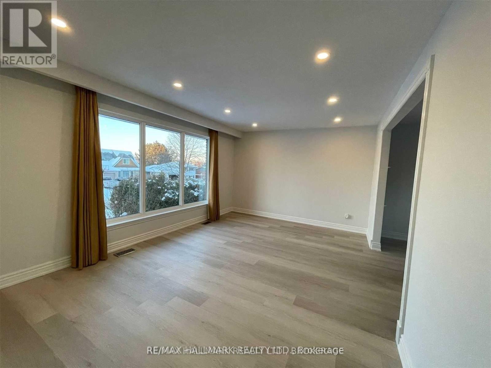 A spacious room with a large window and a view of the outdoors.