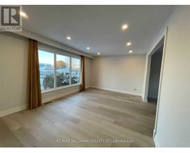 A spacious room with a large window and a view of the outdoors.