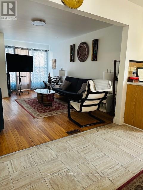 A living room with a black and white couch and a flat screen TV.