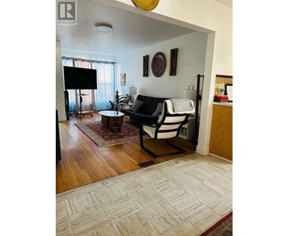 A living room with a black and white couch and a flat screen TV.