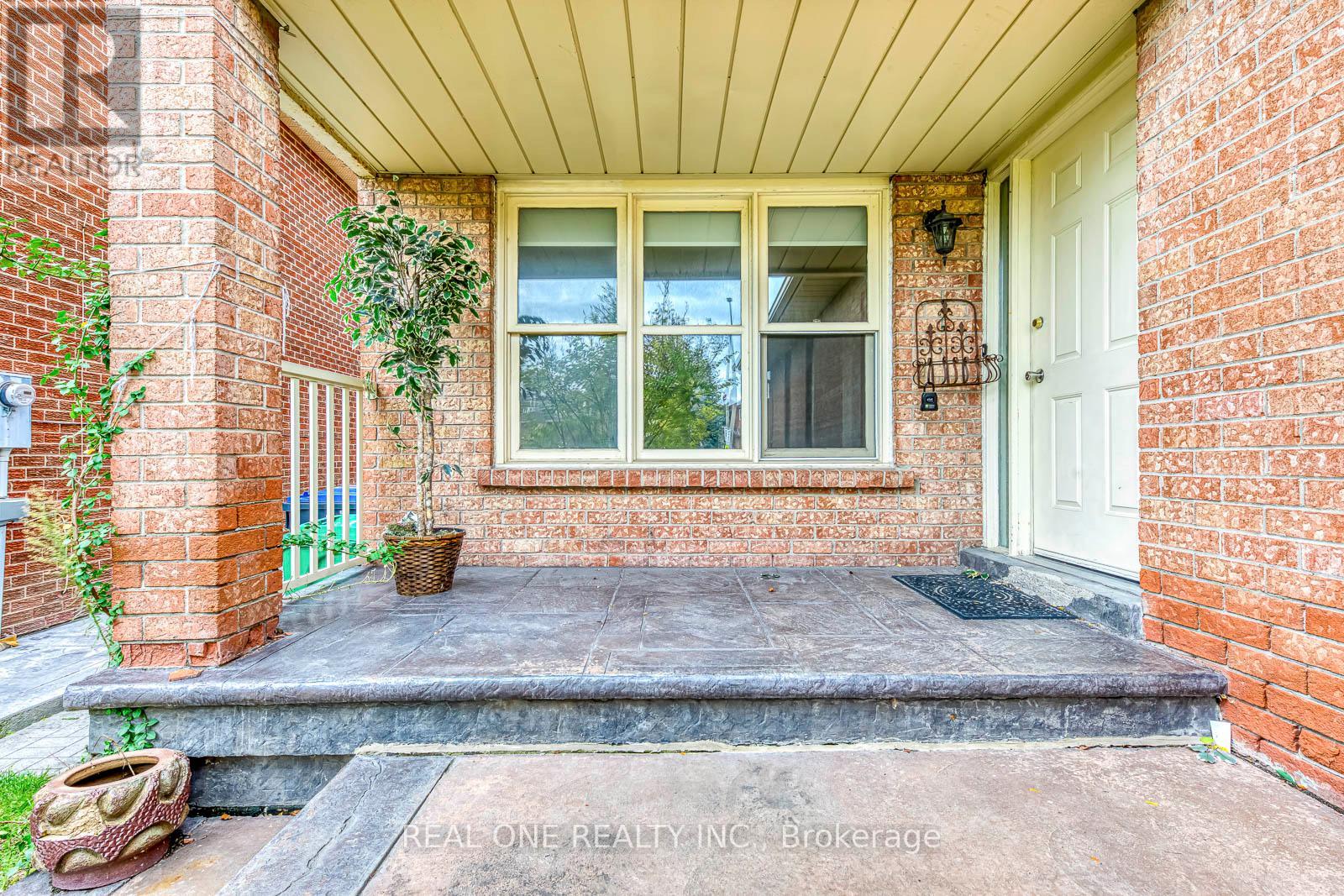 A front porch with a white door and a window.