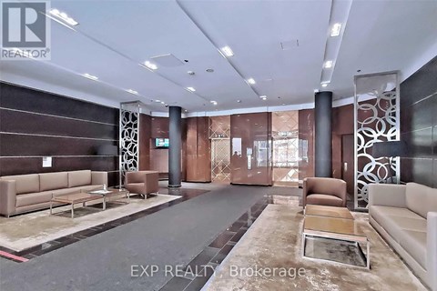 A spacious living room with a long couch and a coffee table in the center.