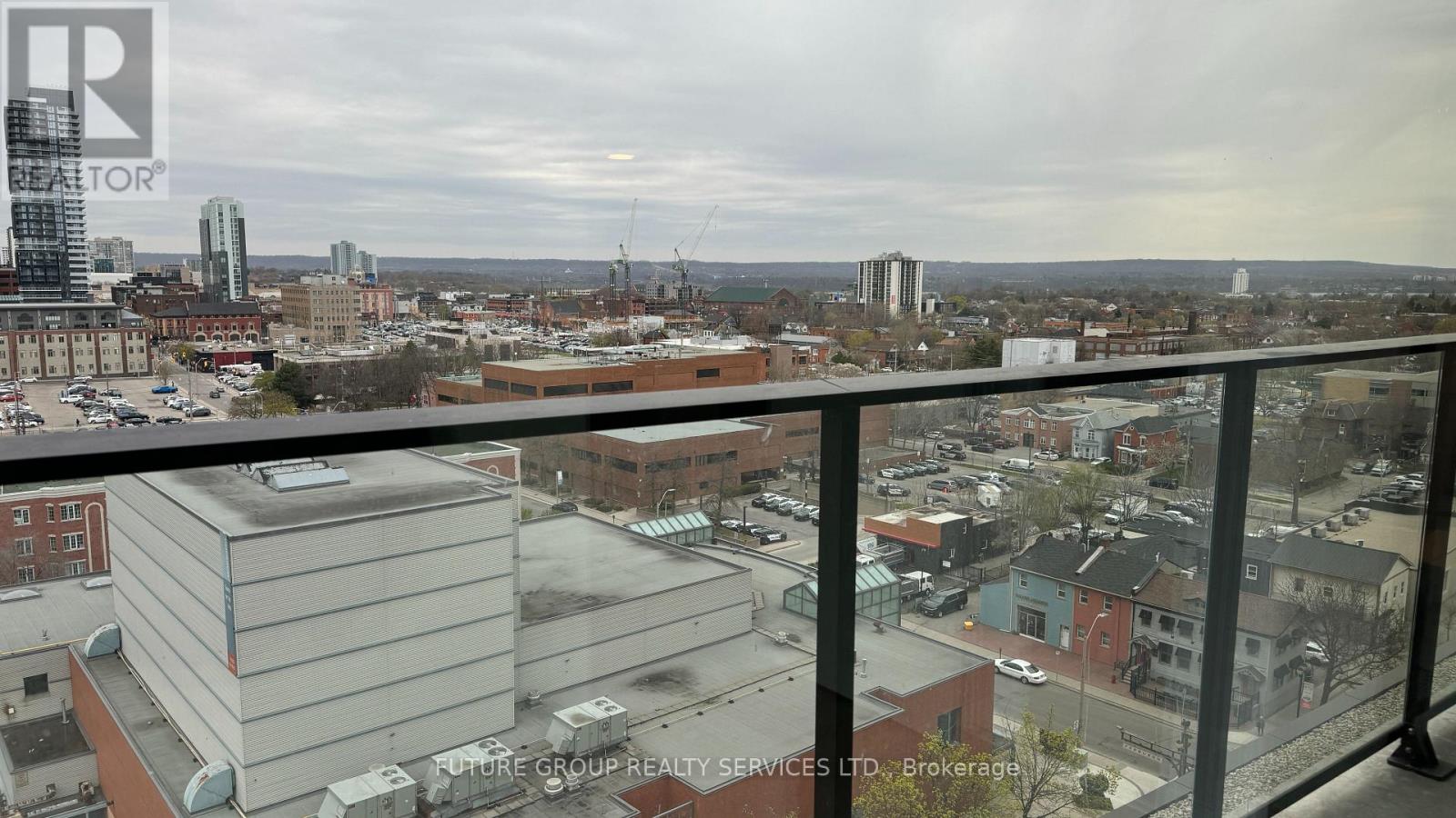 A view of a city from a balcony with a building in the foreground.