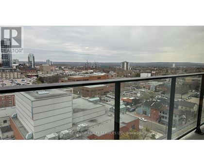 A view of a city from a balcony with a building in the foreground.