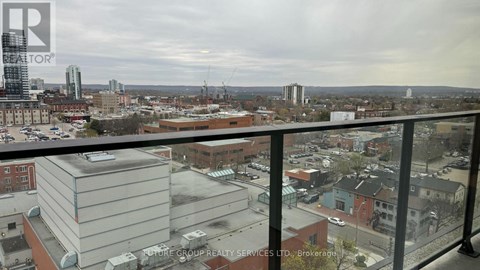 A view of a city from a balcony with a building in the foreground.