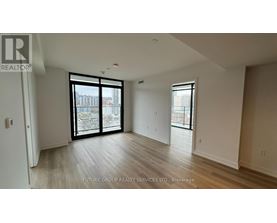 A spacious room with a sliding glass door leading to a balcony.