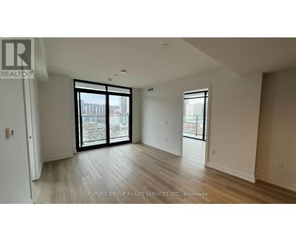 A spacious room with a sliding glass door leading to a balcony.