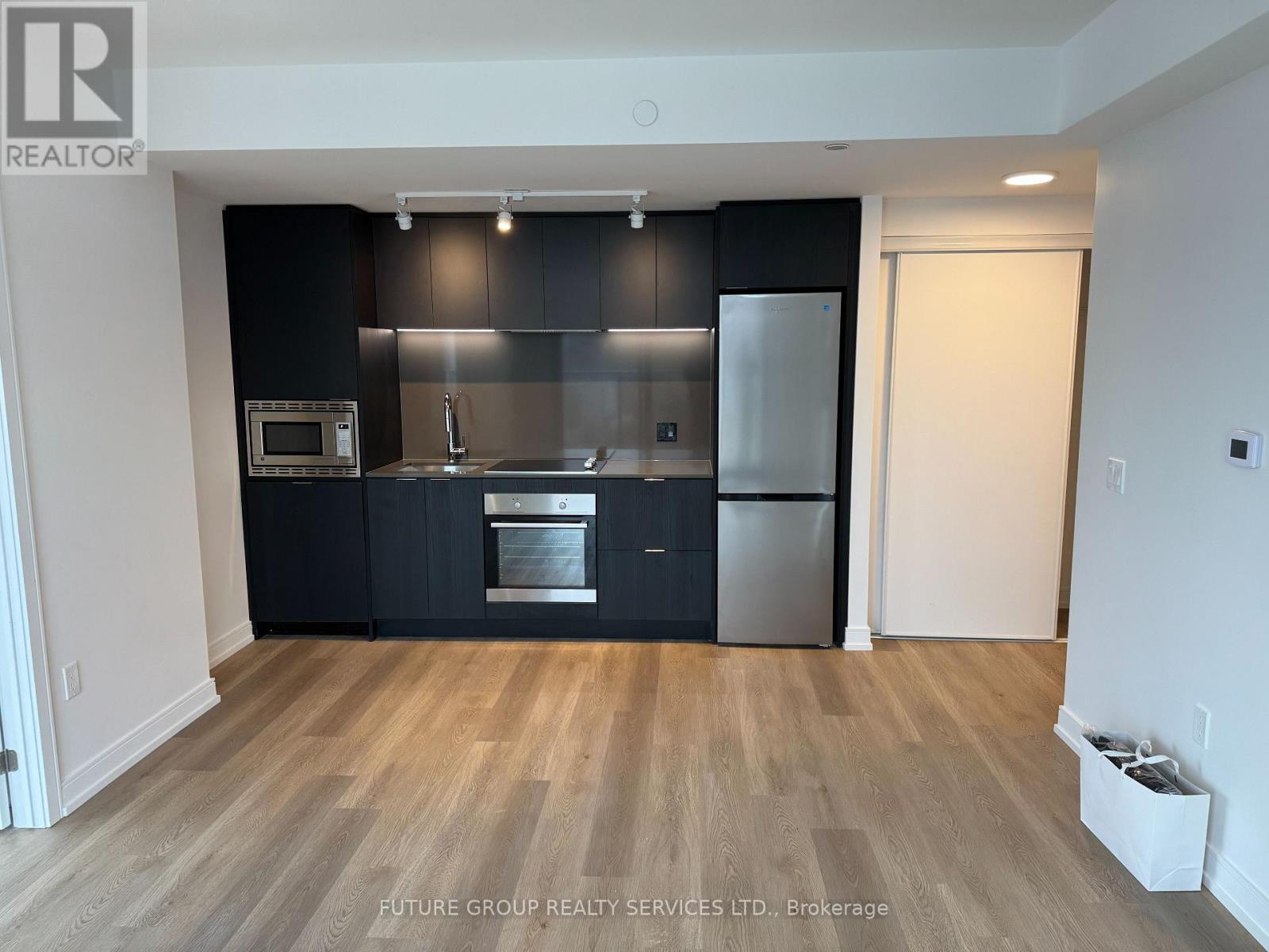 A kitchen with black cabinets and stainless steel appliances.