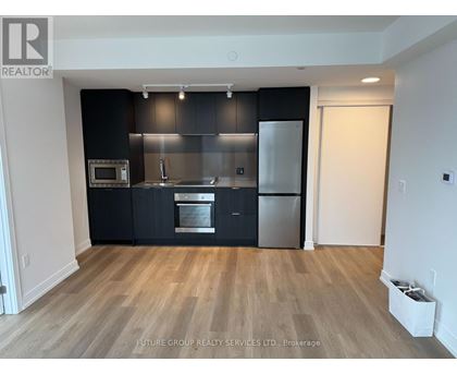 A kitchen with black cabinets and stainless steel appliances.