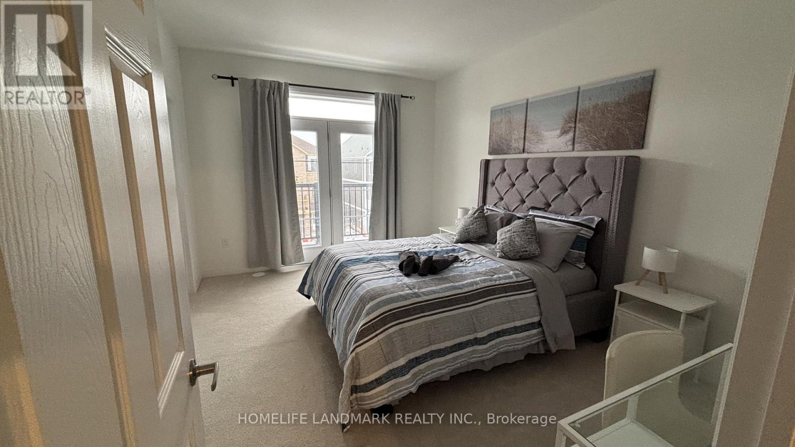 A bedroom with a bed, nightstand, and window.