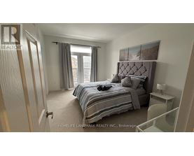A bedroom with a bed, nightstand, and window.