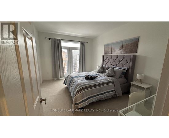 A bedroom with a bed, nightstand, and window.