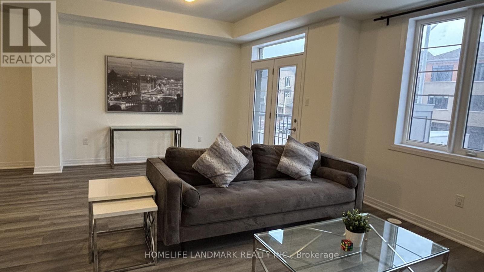 A living room with a couch, coffee table, and a picture on the wall.