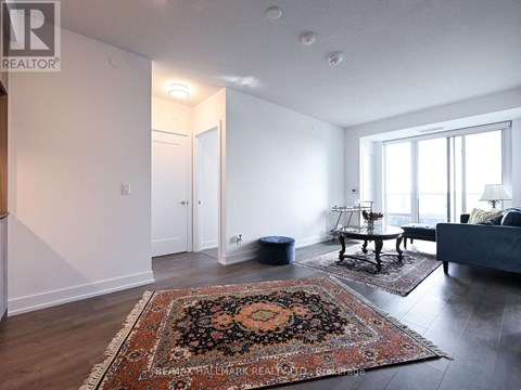 A living room with a rug on the floor and a couch.