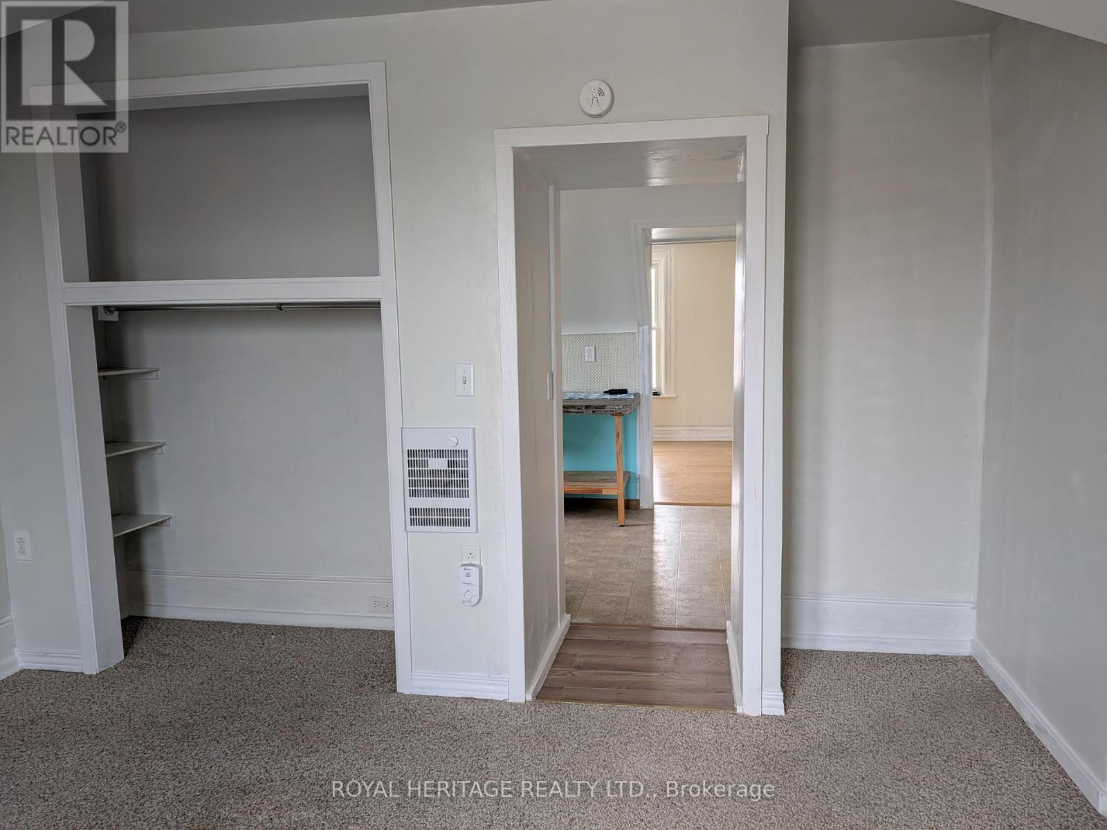 A bedroom with a bed and a window is visible through an open door.