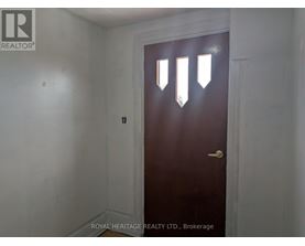 A dark brown door with a gold handle in a white room.