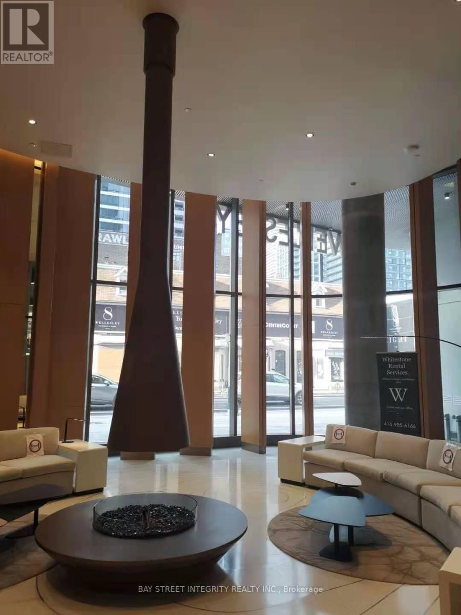 A large room with a couch, a table and a tall column.