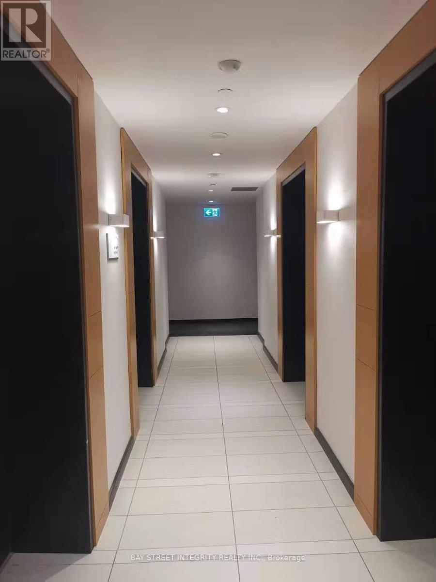 A long hallway with doors on both sides and a blue sign in the middle.