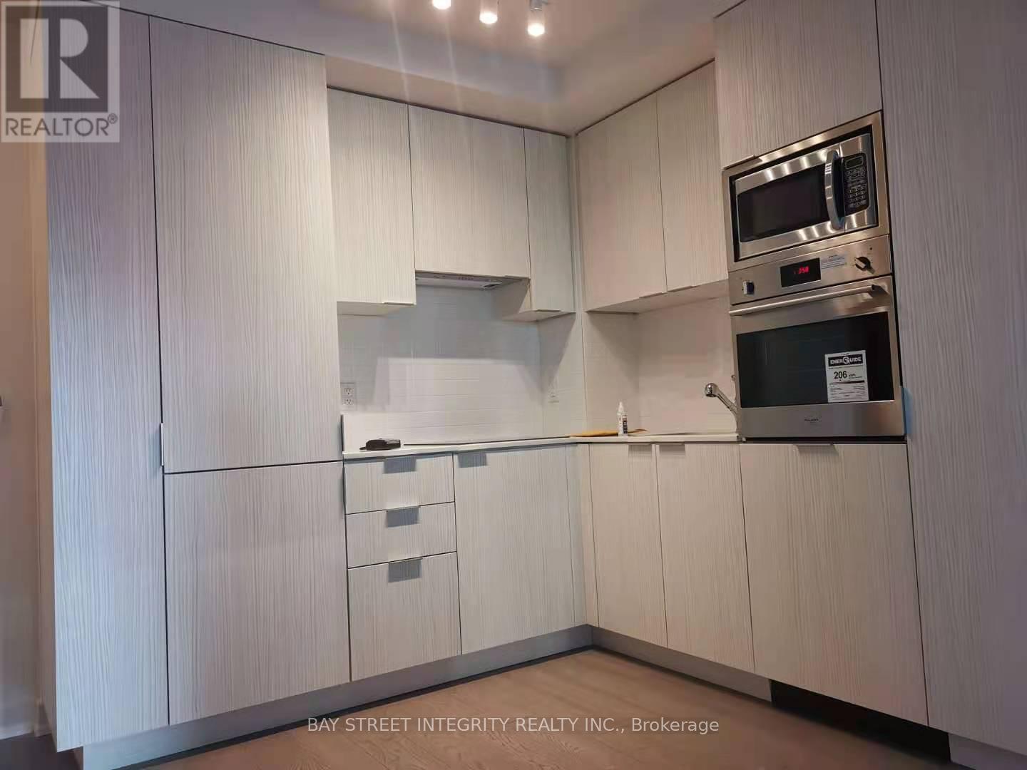 A kitchen with white cabinets and a microwave above the stove.