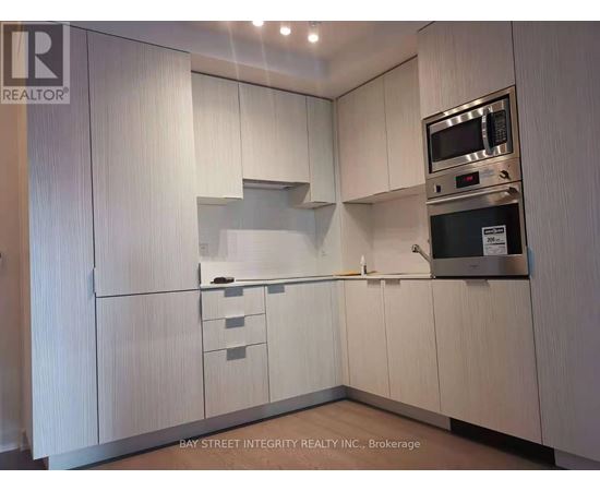 A kitchen with white cabinets and a microwave above the stove.