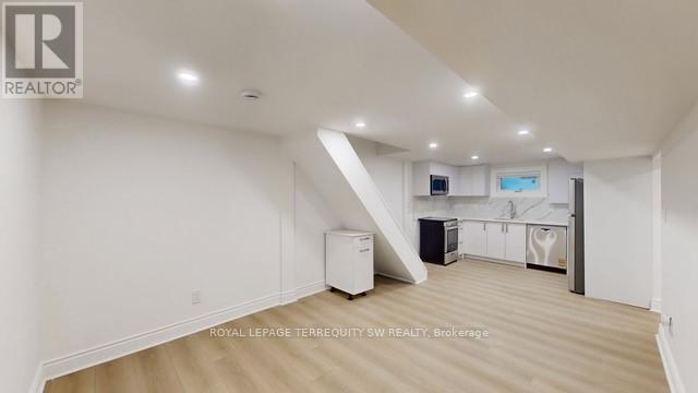 A spacious, empty room with a staircase leading to the next level.