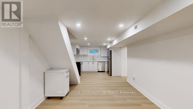 A spacious, empty room with white walls and a wooden floor.