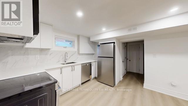 A kitchen with white cabinets and a black counter top.