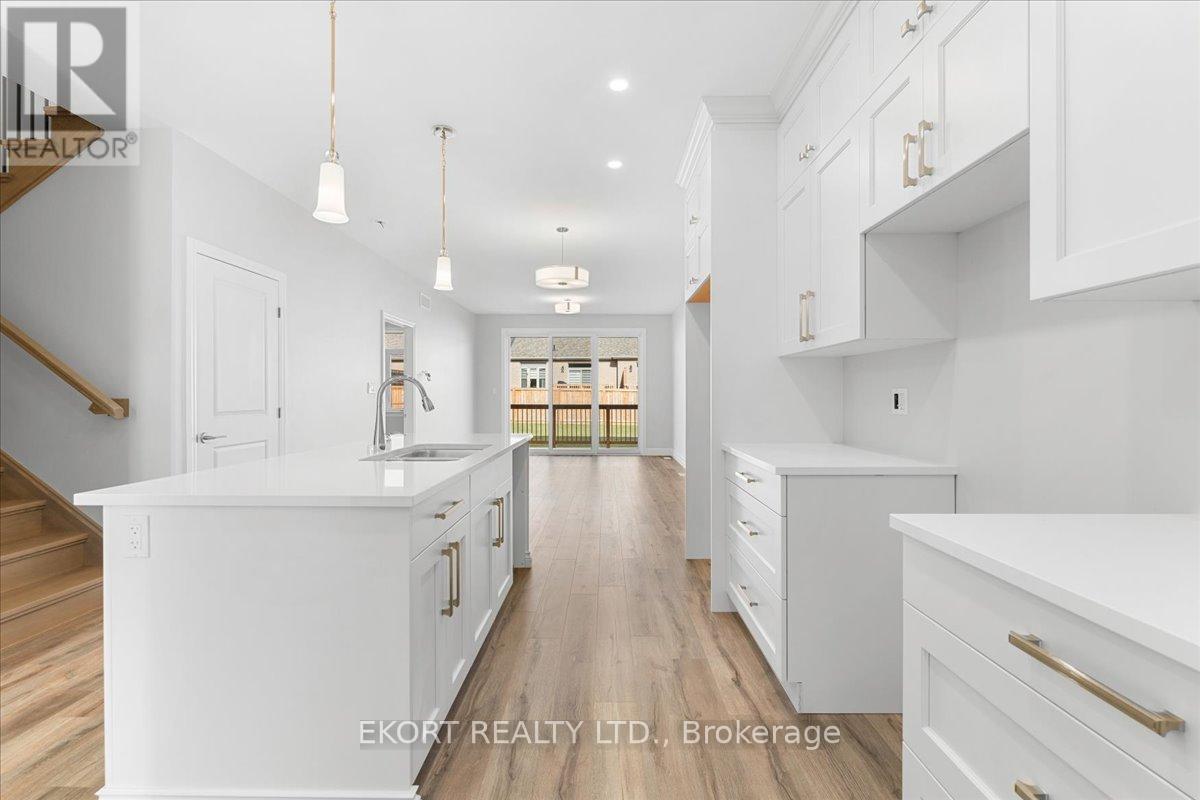 A spacious kitchen with white cabinets and a wooden floor.