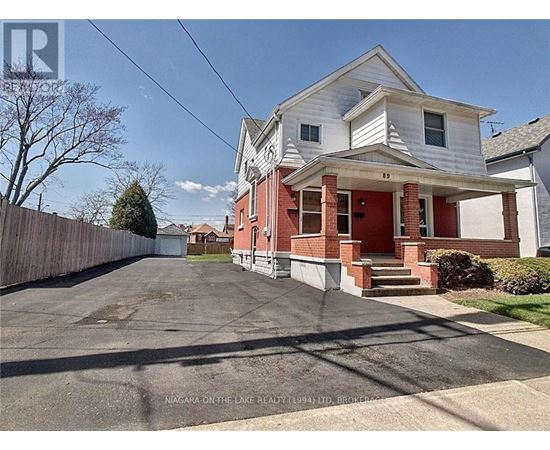 A house with a red front porch and a white garage door is for sale.