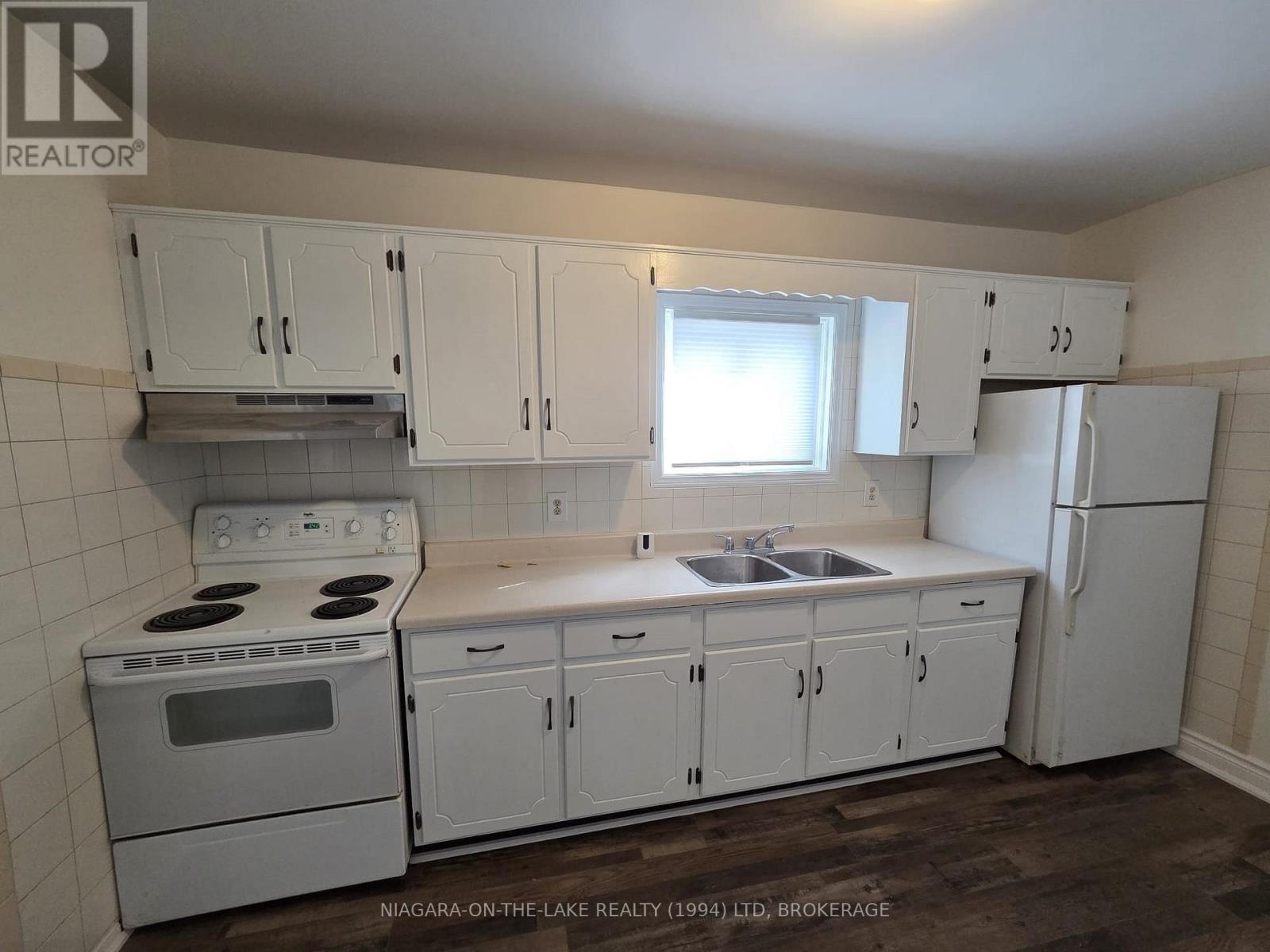 A kitchen with white cabinets and appliances.
