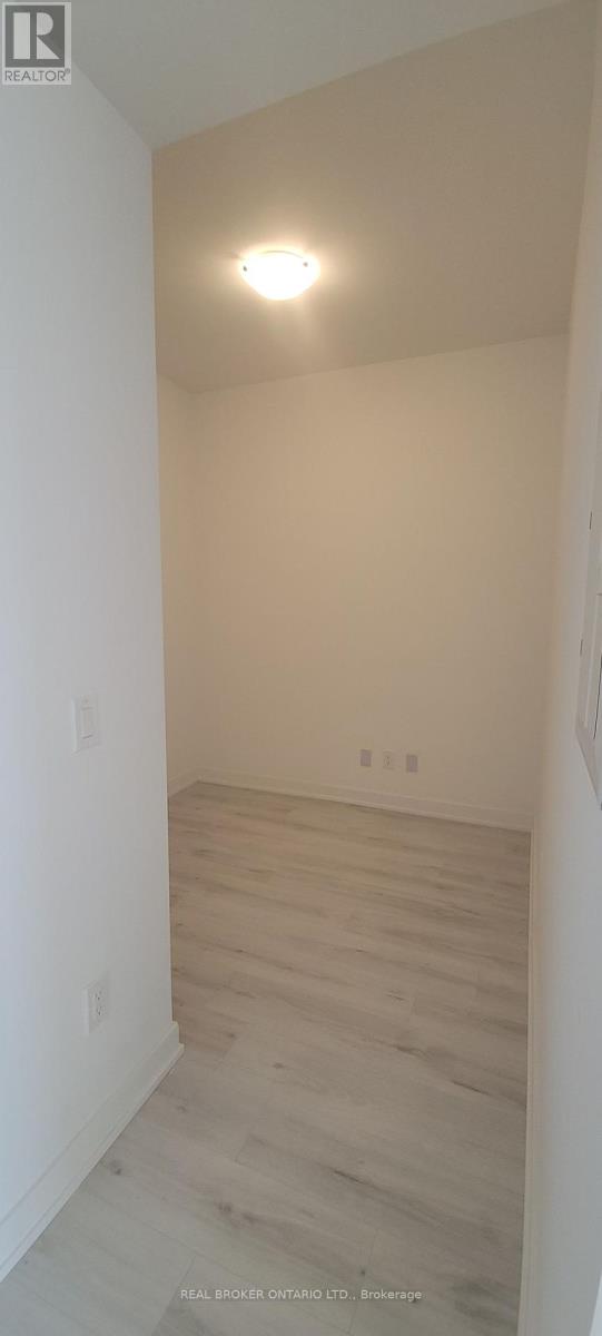 A room with a light on the ceiling and wooden flooring.