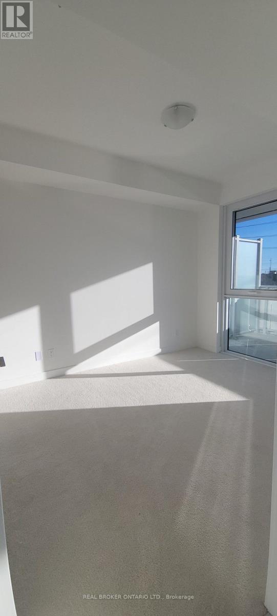 A room with white walls and a window letting in sunlight.