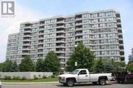 A white pickup truck is parked in front of a large apartment building.