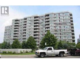 A white pickup truck is parked in front of a large apartment building.