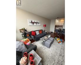 A bedroom with a bed, nightstand, and television.