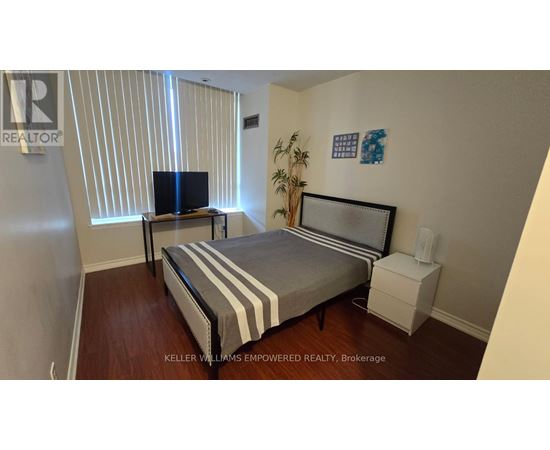 A bedroom with a bed, nightstand, and television.