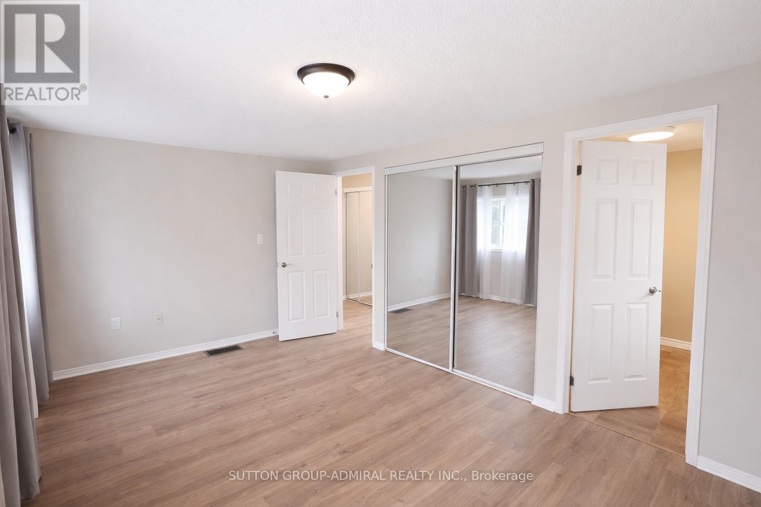 A spacious room with a sliding glass door leading to a balcony.
