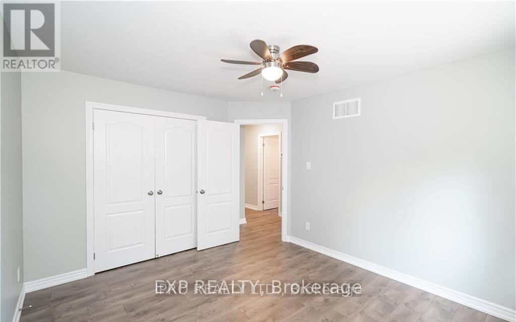 A room with a ceiling fan and a doorway leading to another room.