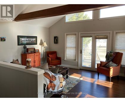 A living room with a couch, chair, and a painting on the wall.