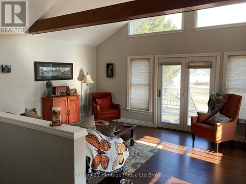A living room with a couch, chair, and a painting on the wall.
