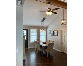A dining room with a table and chairs.