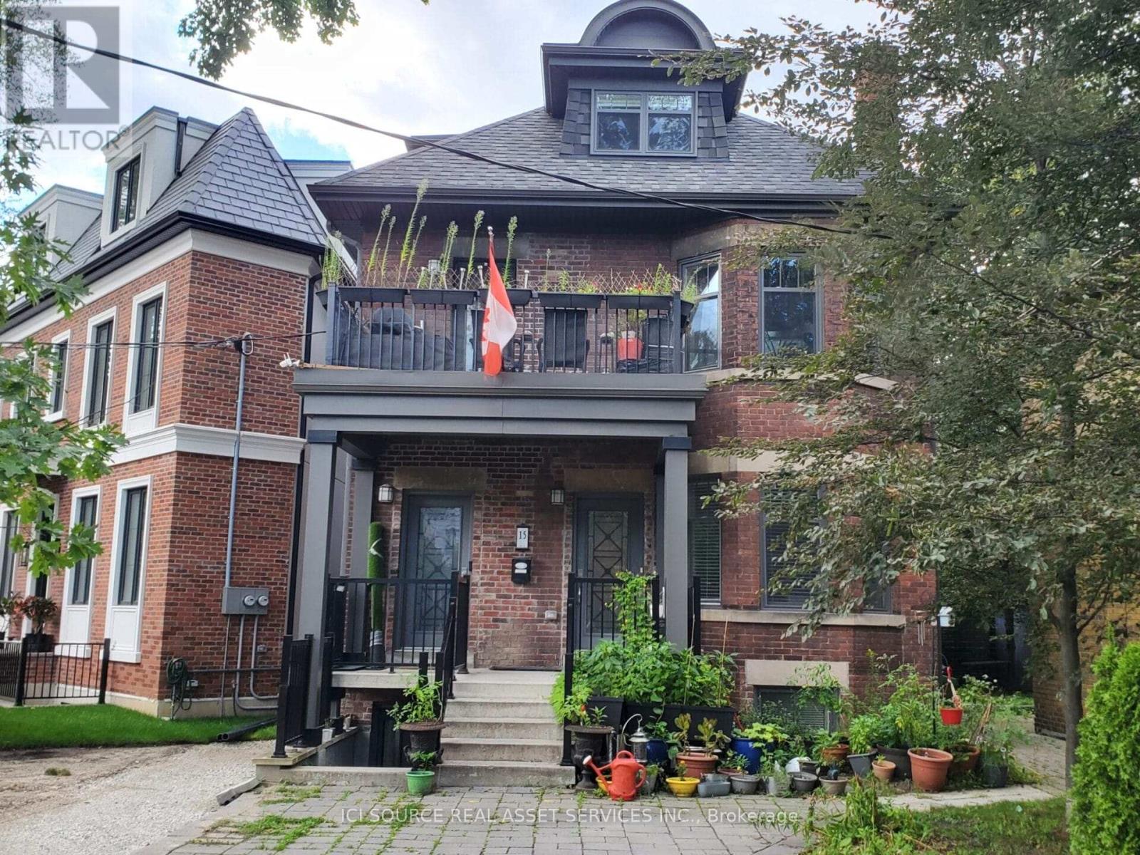 A house with a black front door and a balcony with a flag on it.