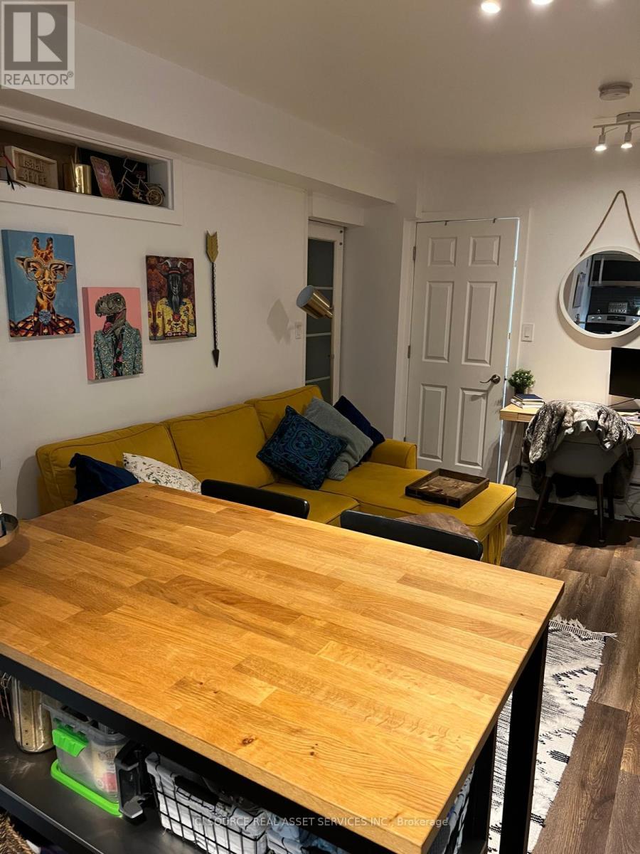 A living room with a yellow couch and a wooden table.
