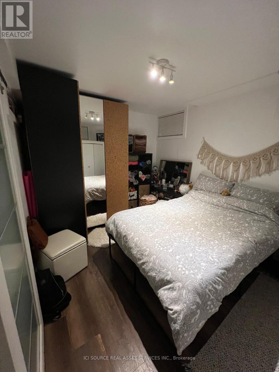 A bedroom with a bed, a mirror, and a dresser.