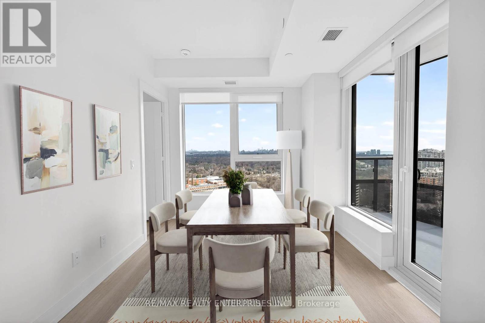 A dining room with a table and chairs and a view of the city.