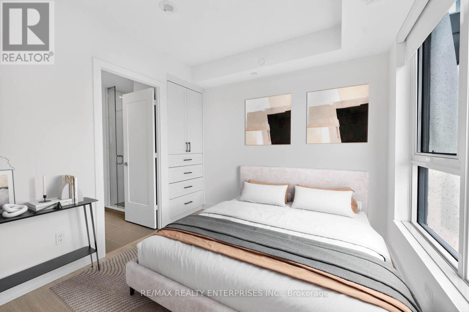 A bedroom with a bed, nightstand, and a window with a view of a rainy day.