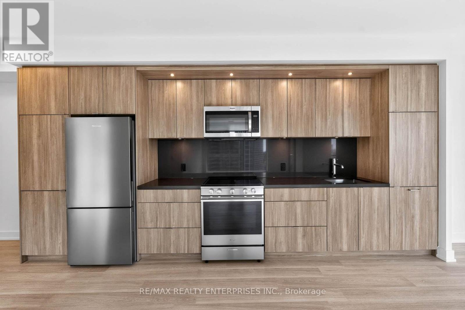 A modern kitchen with wooden cabinets and stainless steel appliances.